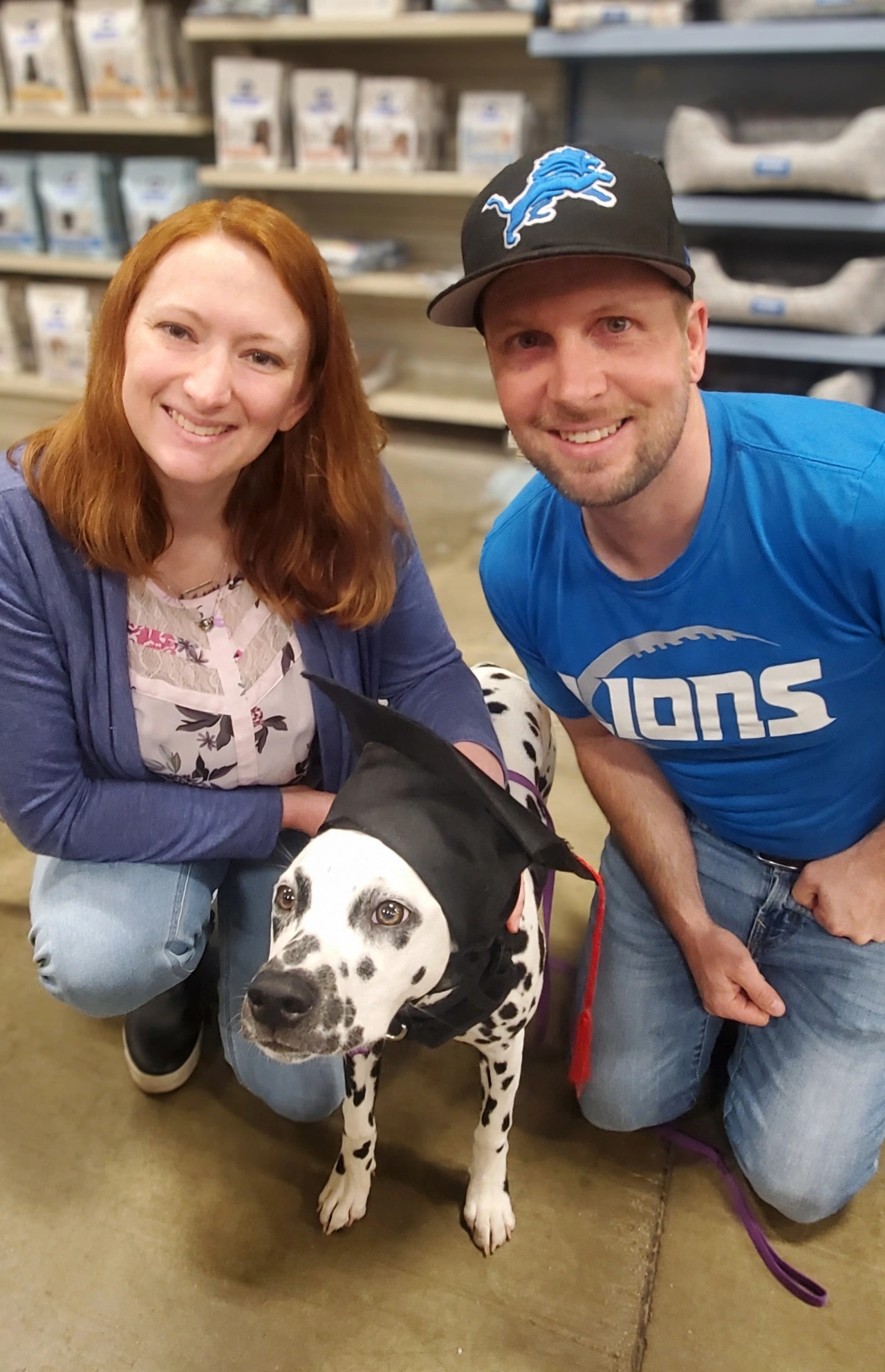 Sean and his wife with their Dalmatian wearing a graduation cap